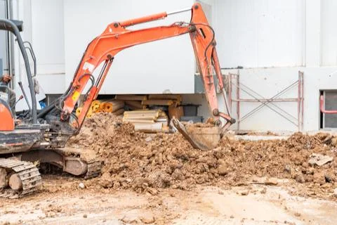 Small excavator digs the foundations of the building. Foto stock