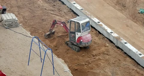 A small excavator works on the construction site of a building. Stock Footage 166902327