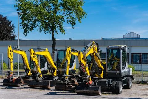 Small excavators standing in a row. Stock Photos