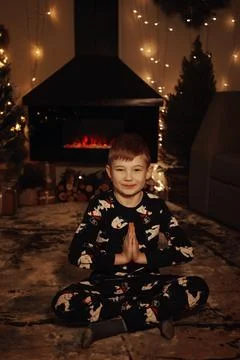 A small, fair-haired boy laughs and plays against the background of a Christmas Stock Photos