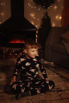 A small, fair-haired boy laughs and plays against the background of a Christmas Stock Photos