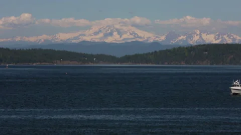 SMALL FAST WHITE BOAT IN OCEAN IN FRONT OF LARGE SNOWY COASTAL MOUNTAINS Stock Footage 52210971