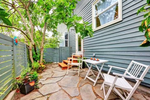 Small fenced back yard with stone floor and chairs. Northwest, USA Stock Photos