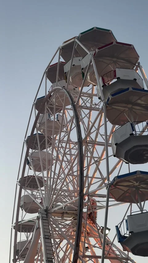 A small ferris wheel, decorated with bright lights, works without visitors Stock Footage 322009005
