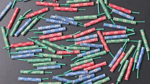 Small firecrackers of different colors on a black background Stock Footage 267300903