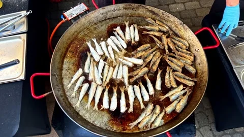 Small Fish are Being Fried in a Large Pan, cooking Evenly Over Hot Oil - Close Stock Footage 336240723