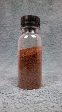 Small Fish Feed Pellets Stored Inside Transparent Plastic Bottle on Soft Te.. Stock Photos