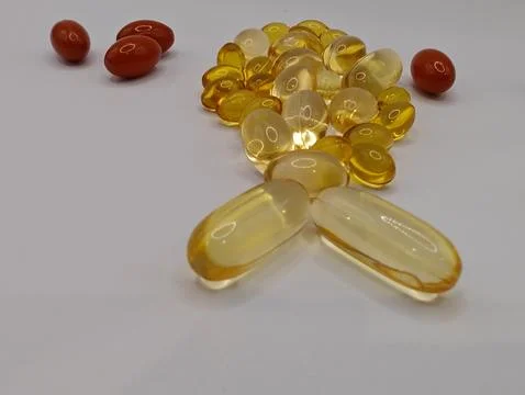 The small fish on a white background consists of omega 3 capsules and various vi Stock Photos
