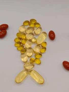 The small fish on a white background consists of omega-3 capsules and large vita Stock Photos