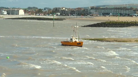 A small fishing boat braces the waves at Morcambe Bay, UK Stock Footage 105683035
