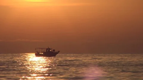 Small Fishing Boat Coming from Work in Red Sunset Light Ocean Scenery Stock Footage