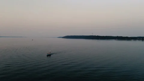 Small Fishing Boat driving back to the port into the sunset 스톡 동영상 114930341