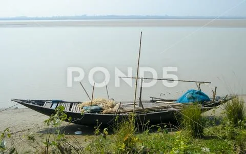 Photograph: A Small Fishing boat (nautical vessel) with Commercial Fishing  net on Ganges #121199832