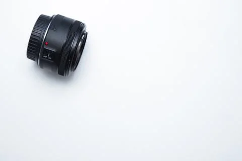 A small fixed lens for a professional camera lies sideways on a white background Stock Photos