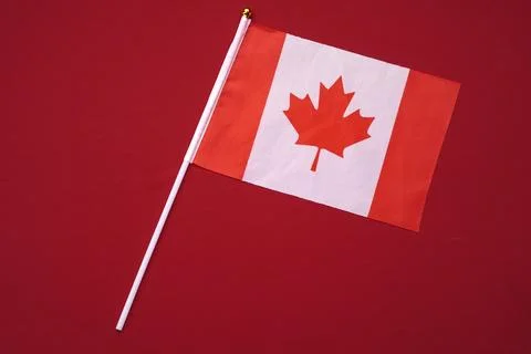 Small flag of Canada isolated red background. Stock Photos