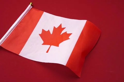 Small flag of Canada isolated red background. Stock Photos