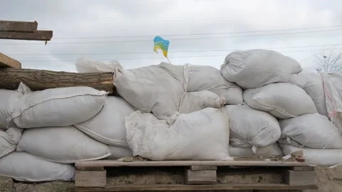 A small flag of Ukraine, installed on a barricade of white bags of sand. Stock Footage 233287550