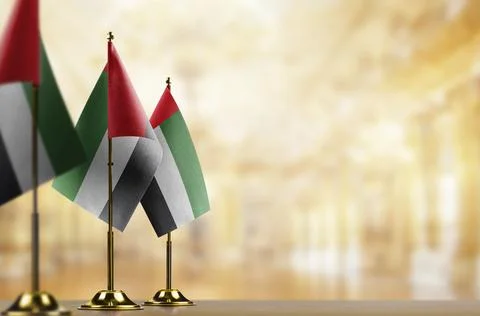 Small flags of the Arab Emirates on an abstract blurry background Stock Illustration