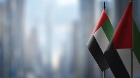 Small flags of the Arab Emirates on an abstract blurry background Stock Illustration