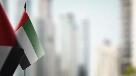 Small flags of the Arab Emirates on an abstract blurry background Stock Illustration
