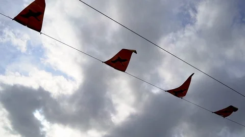 Small flags fluttering in wind hanging on rope on cloudy sky background Video stock 121395939