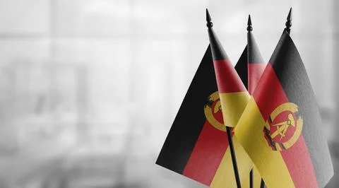 Small flags of the GDR on an abstract blurry background Stock-Illustration
