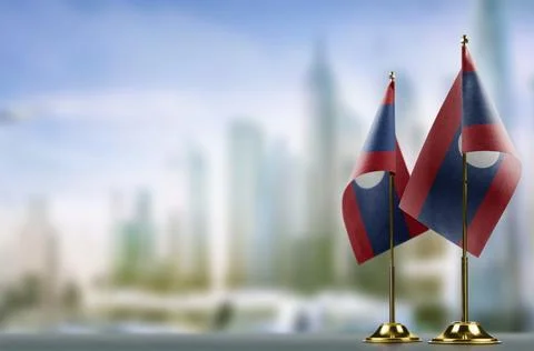 Small flags of the Laos on an abstract blurry background Stock Illustration