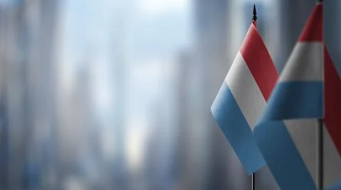 Small flags of the Luxembourg on an abstract blurry background Stock Illustration