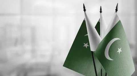 Small flags of the Pakistan on an abstract blurry background Stock Illustration