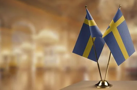 Small flags of the Sweden on an abstract blurry background Stock Illustration