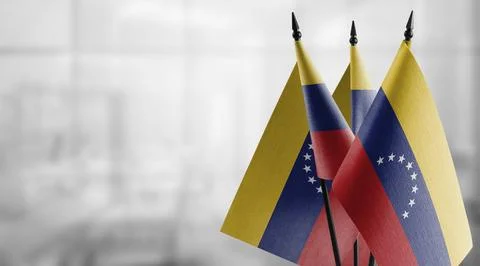 Small flags of the Venezuela on an abstract blurry background Stock Illustration