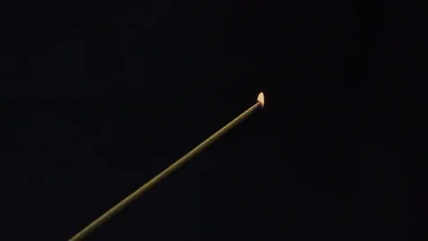 Small flame of lit incense stick grows larger. Close up of tiny flame of Stock Footage 112357985