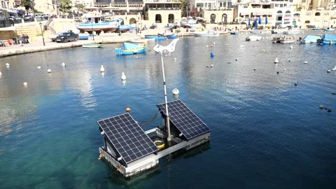 Small floating dock with black solar panels on blue calm water in a harbour Vidéo 328988455