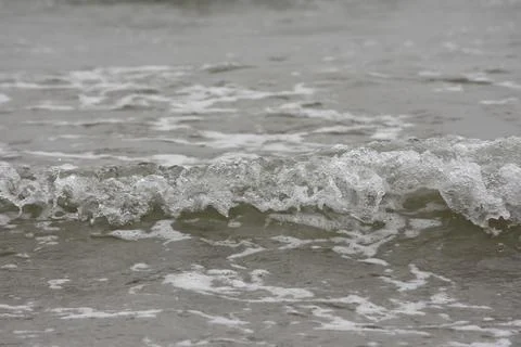 Small foamy ocean wave in shallow water 写真素材