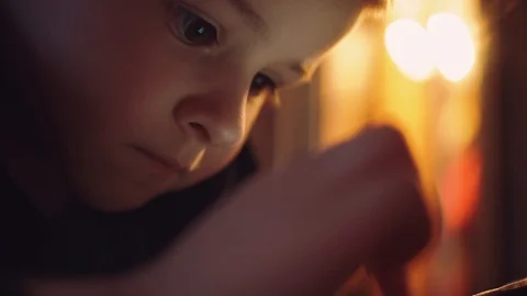 Small focused boy uses a mobile phone. He lies on the floor. He has big brown Stock Footage 88891013
