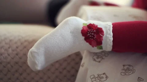 The small foot of an infant. Socks and tights for the baby Stock Footage 87917857