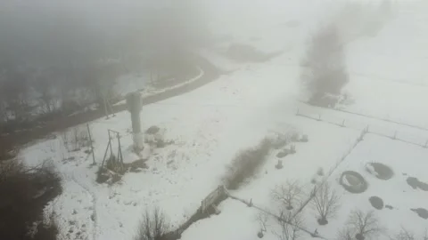 A small forest trees mixed with houses in the fog aerial Stock Footage 198513622