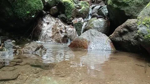 Small Forest Waterfall Flowing Into Rocky Stream – Cinematic Nature Shot Stock Footage 329778278