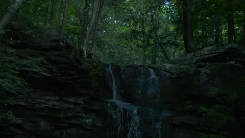 Small forest waterfall, Pan down from trees, 4K Stock Footage 92646919