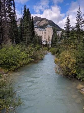 A Small Forested Stream Flows from the Fairmont Chateau Lake Louise Hotel Stock Photos