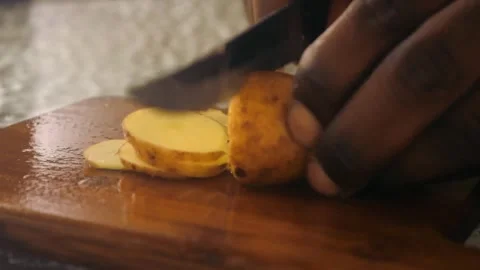 Small fresh picked red potatoes being cut into small slices Video stock 337435171