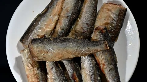 Small Fried Fish Spinning on Plate. Top-Down Seamless Loop of Crispy Whole Fish Stock Footage 325485426