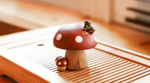 A small frog sitting on a fly agaric. Clay tea figurine, teapet. Stock Photos