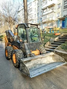 Small front-end loader for loading and unloading on city streets. Stock Photos