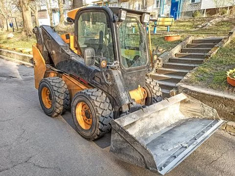 Small front-end loader for loading and unloading on city streets. Stock Photos