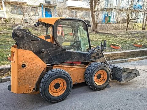 Small front-end loader for loading and unloading on city streets. Stock Photos