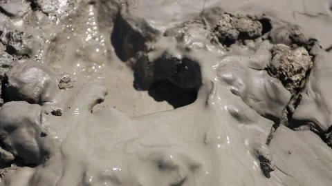 Small gas bubbles erupting through cracked clay inside mud volcano Stock Footage 339270059
