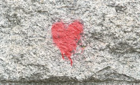 A small generic red heart symbol painted on a wall, heart icon front view, .. Stock Photos
