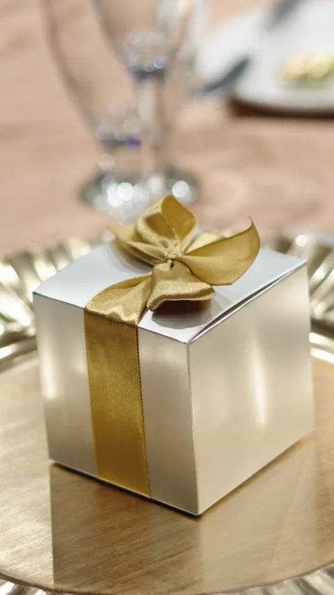 A small gift box for guests next to cutlery at a wedding dinner Stock Footage 270081797