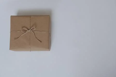 A small gift in craft packaging for all occasions on a white background on the Stock Photos